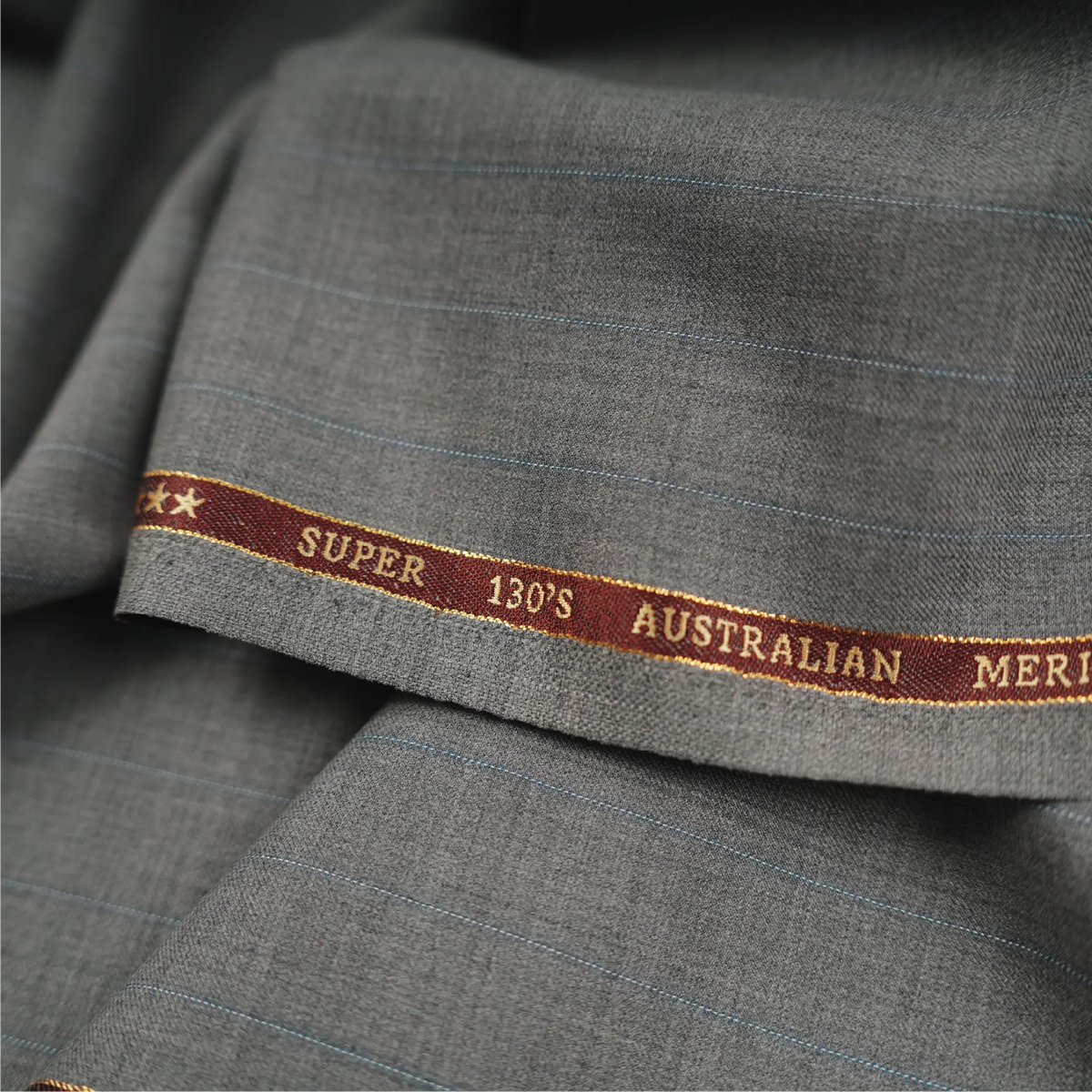 OCM Euphoria Merino Wool 130 light grey pinstripe suiting fabric with branded selvedge