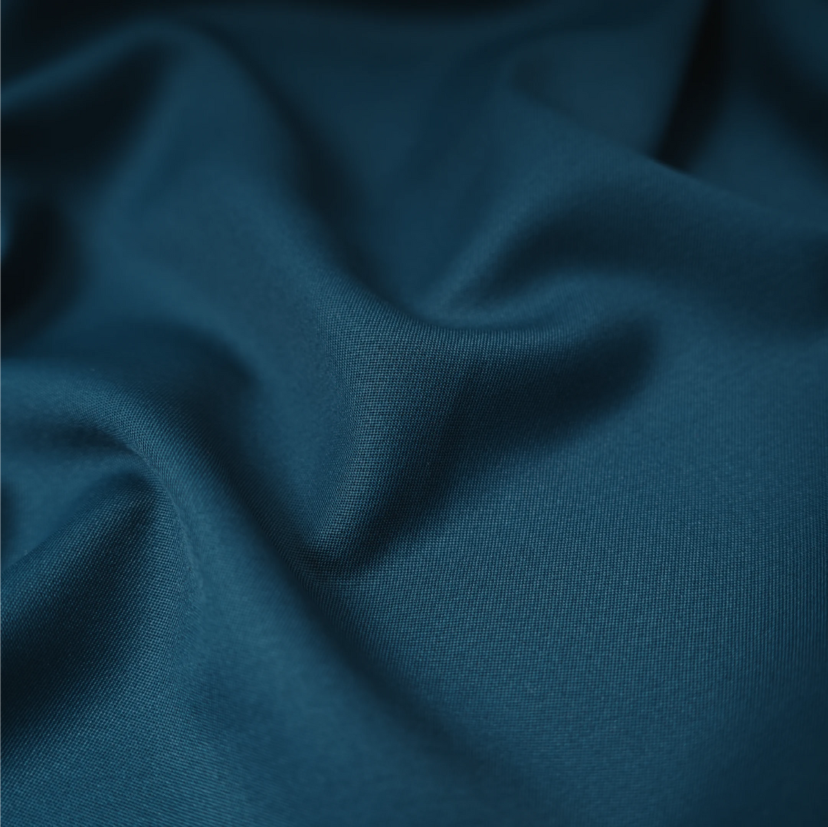 Raymond Elarno teal blue suiting fabric showing its smooth texture and drape