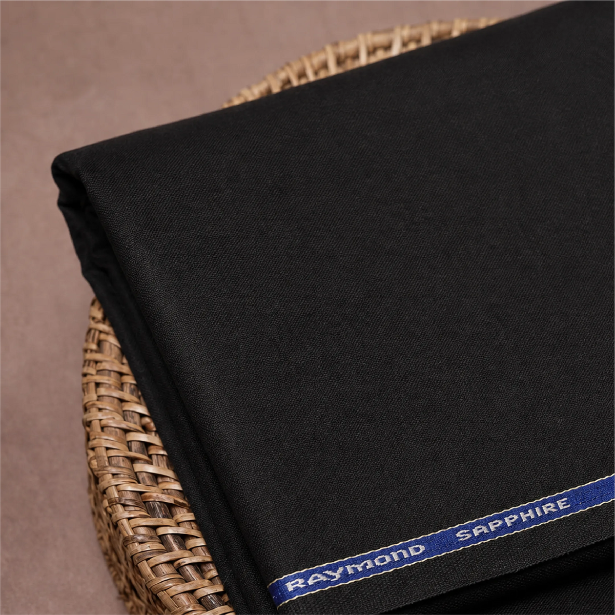 Raymond Sapphire black unstitched suiting fabric neatly folded on a textured surface